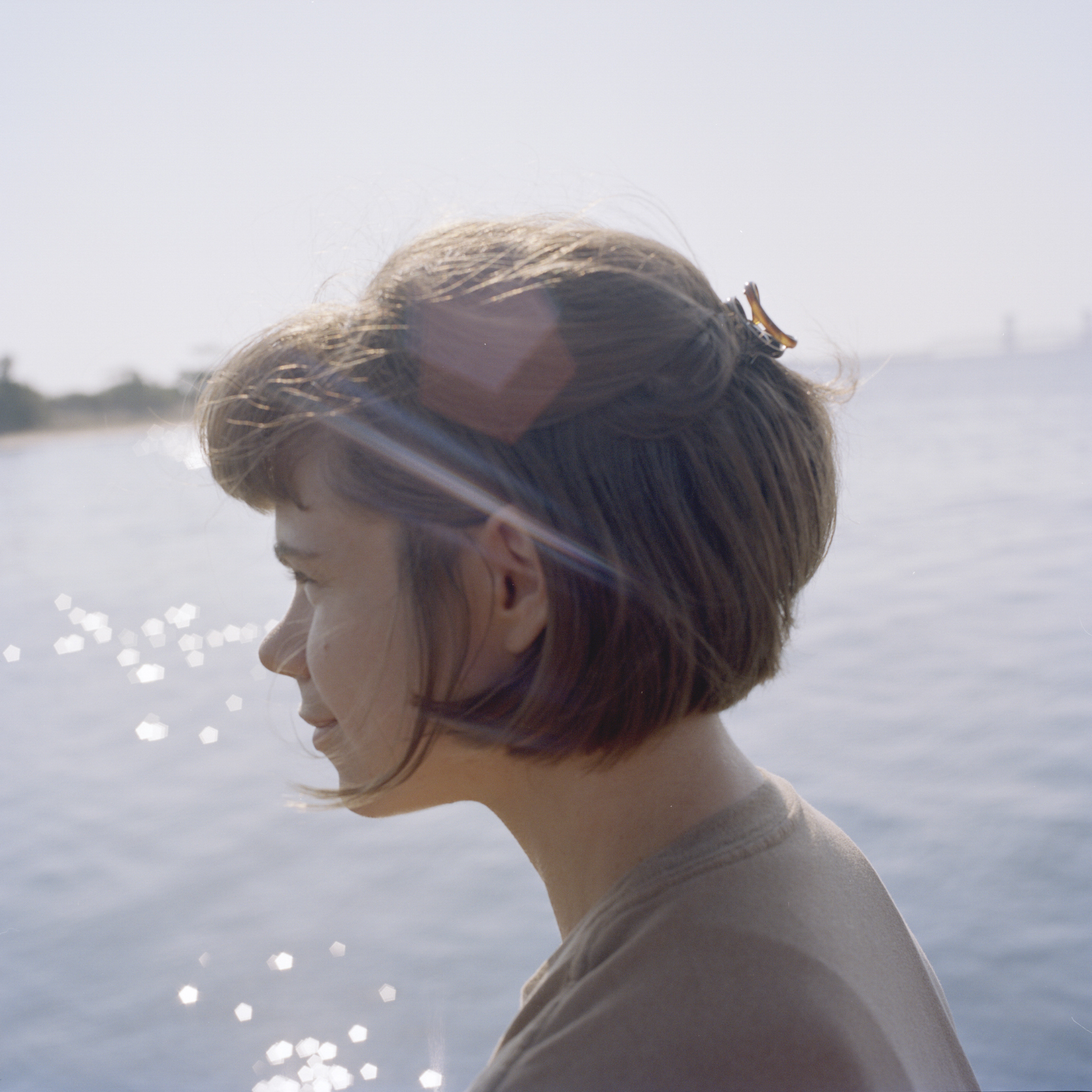 profile photo of laurel with water glimmering behind her, looking off into the distance